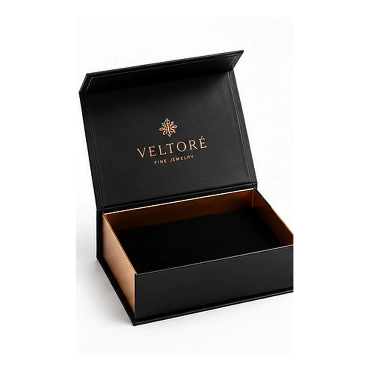 Open charcoal-black magnetic gift box with copper VELTORÉ lettering, gold-trimmed edges, and a dark interior on white.