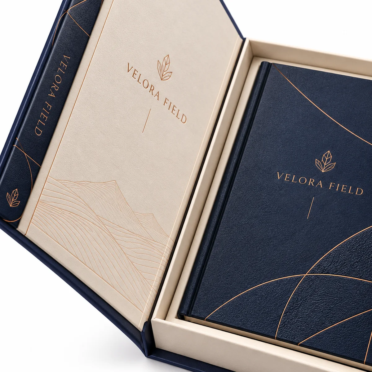 Close-up of a custom booklet box showing its navy spine, copper lettering, textured booklet cover, and ivory wrapped edges.