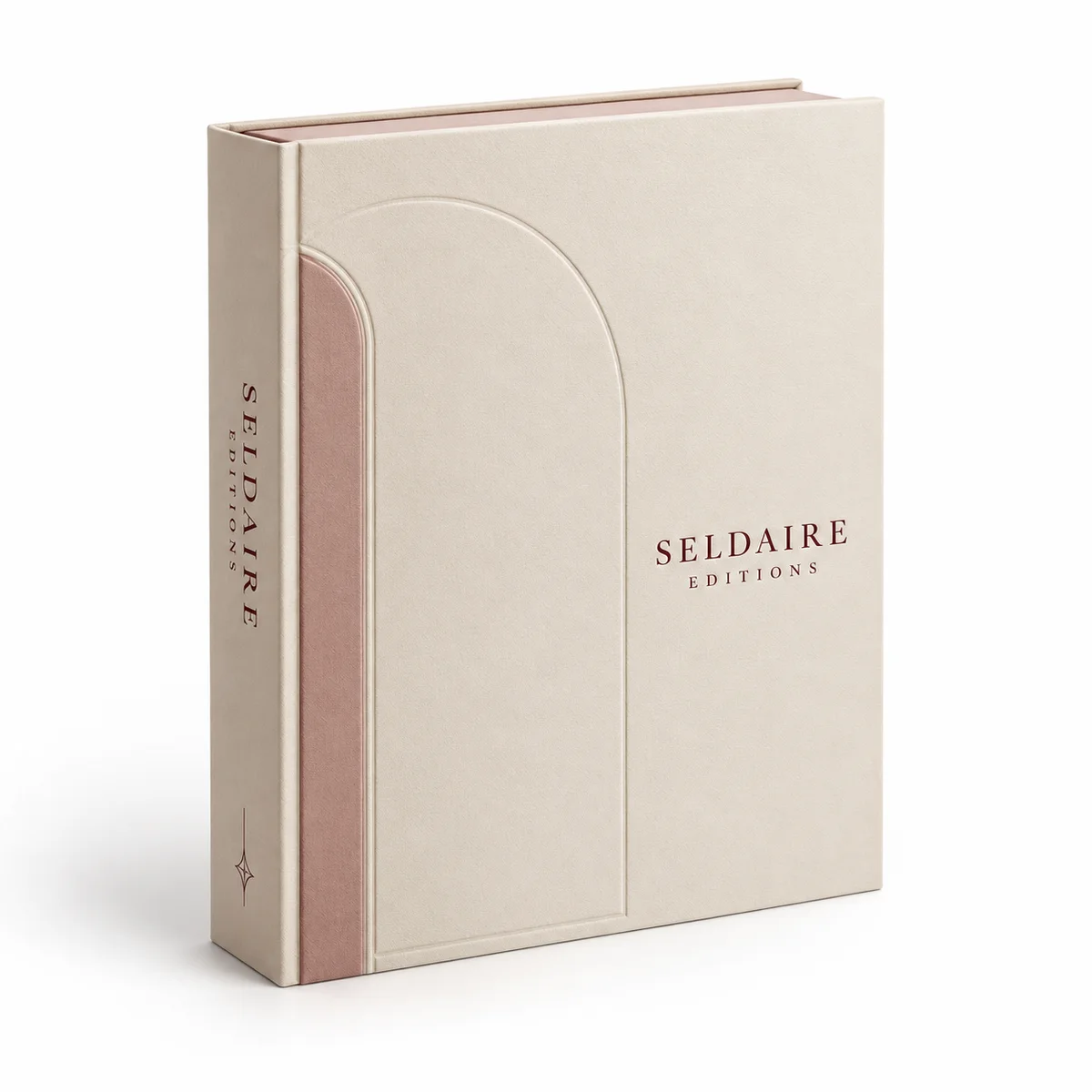 Closed ivory Seldaire Editions custom booklet box with an embossed arch, dusty rose inset, and burgundy lettering, shown at an angle.