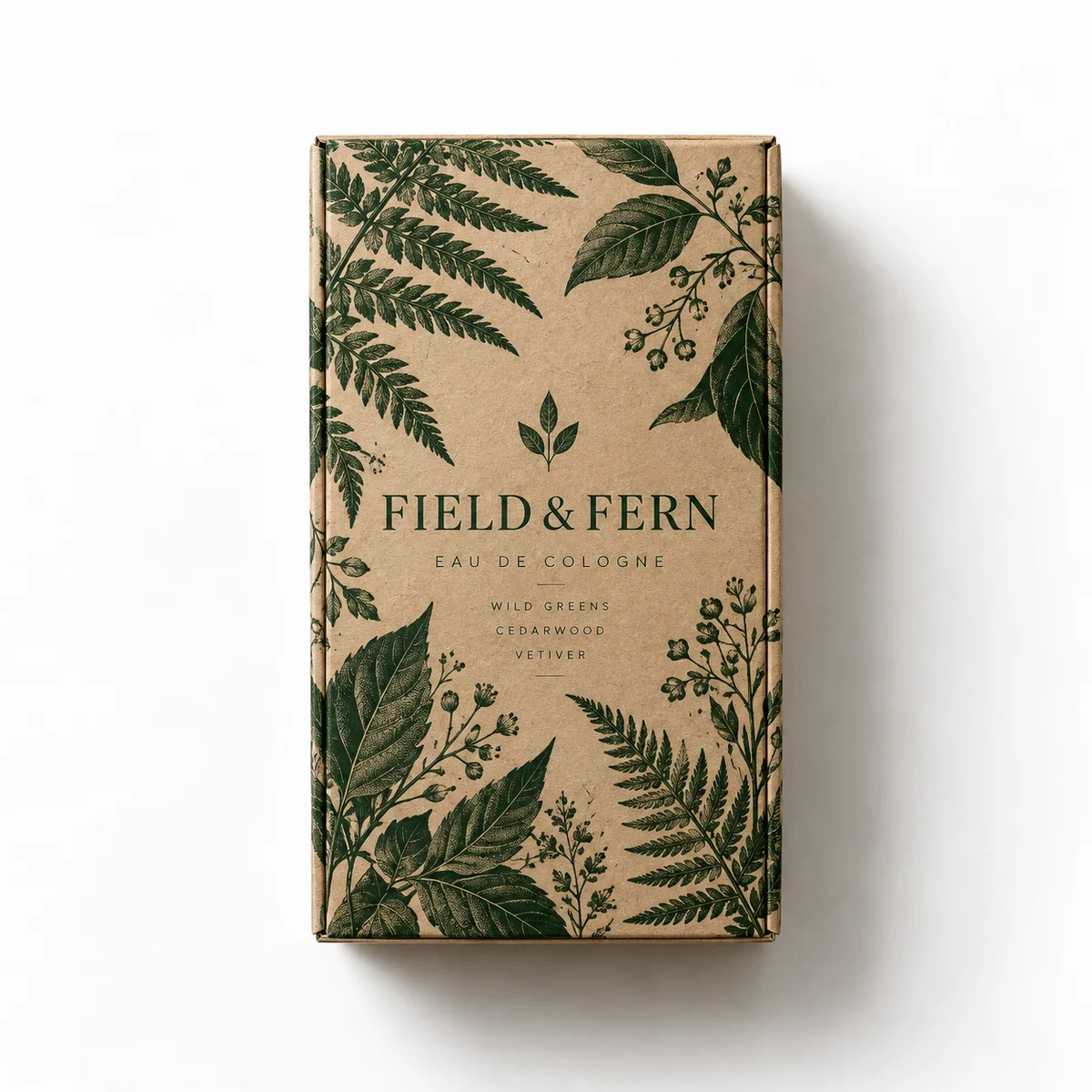 Kraft cologne packaging with forest-green botanical illustrations and FIELD & FERN branding, photographed from above.
