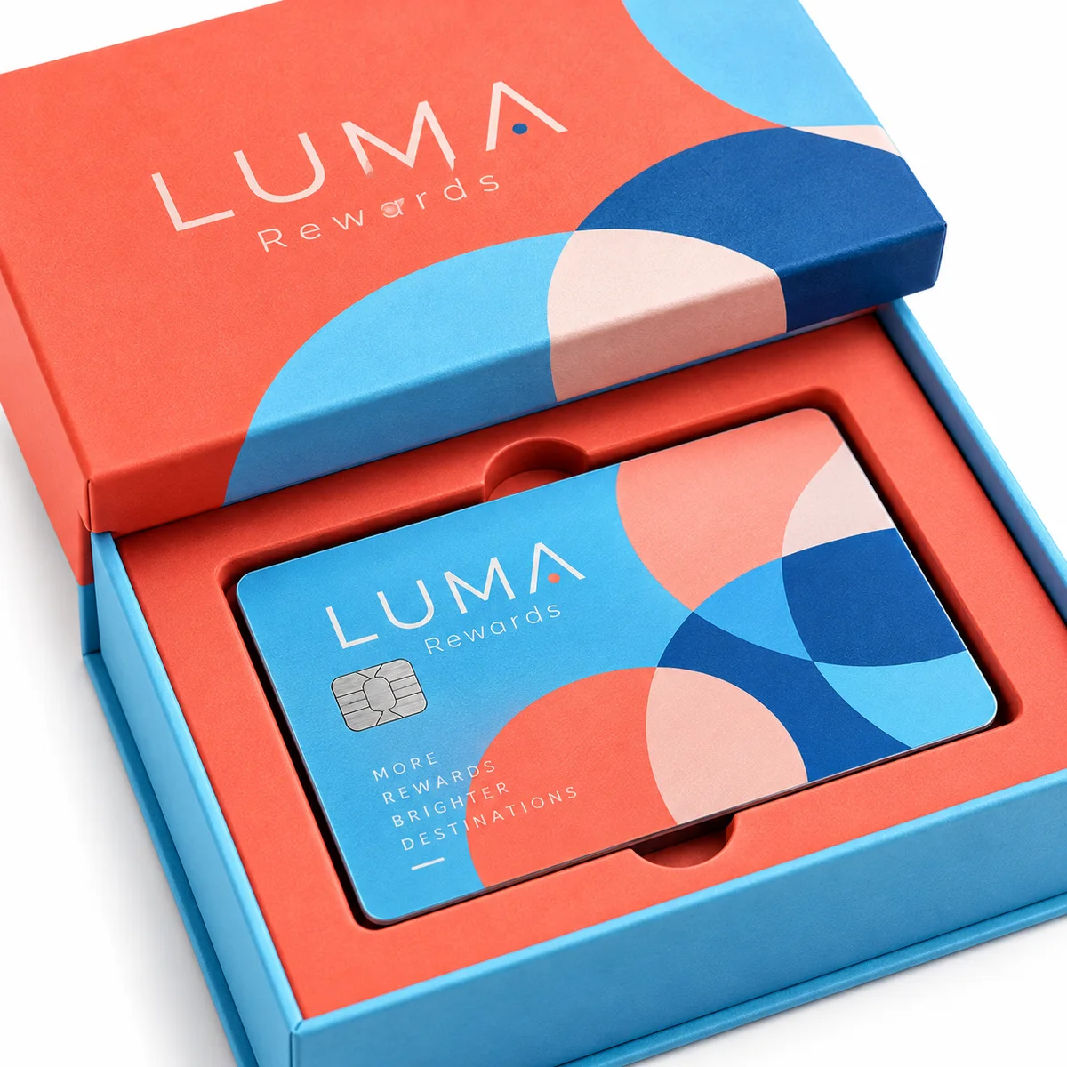 Close-up of LUMA Rewards rigid credit card packaging with coral and sky-blue geometric graphics and a fitted branded card tray.