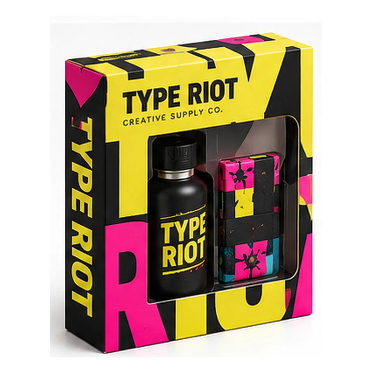 Type Riot gift box with a rectangular window, oversized black lettering on yellow and pink panels, and creative gifts inside.