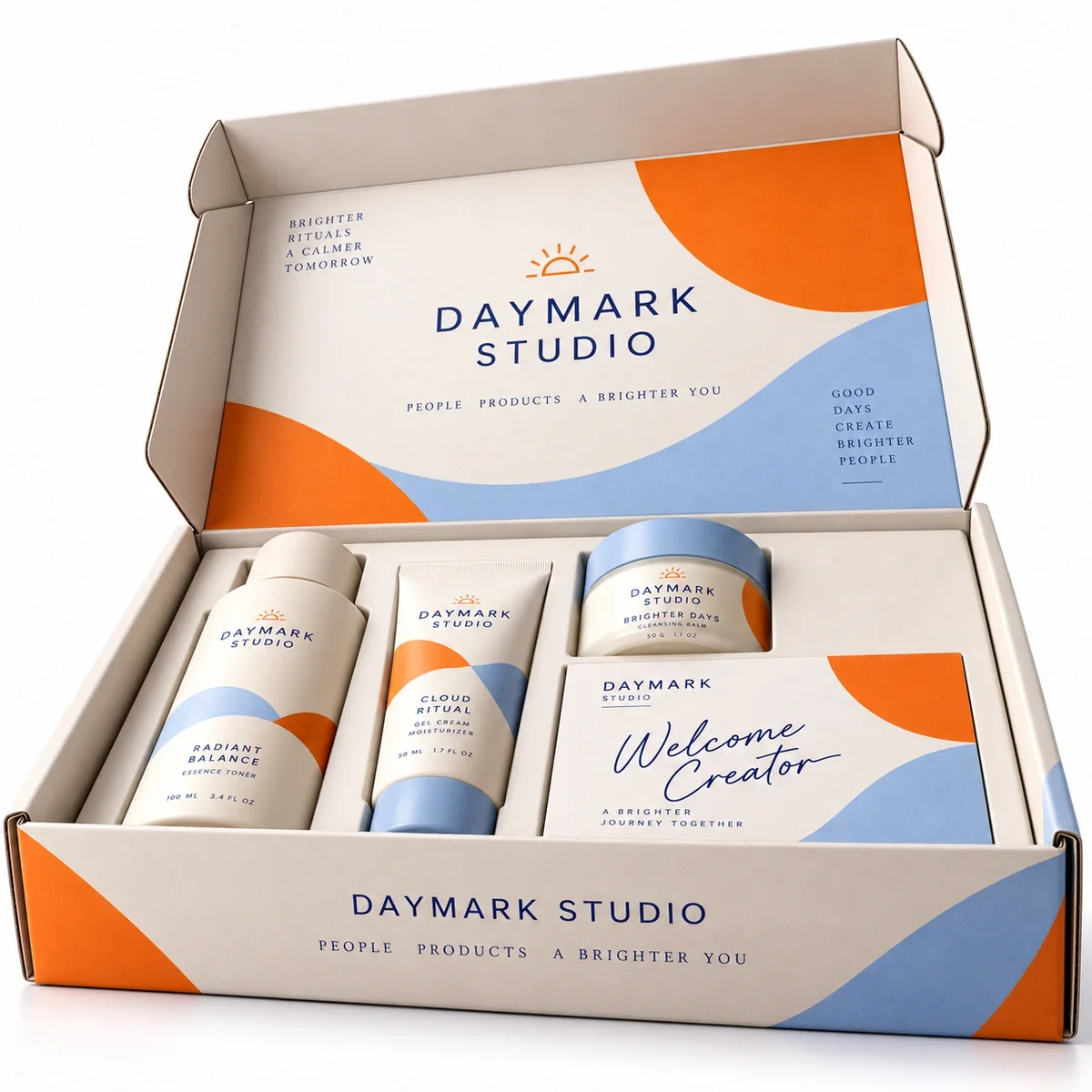 Low-angle view of DAYMARK STUDIO influencer kit packaging with an open printed lid, orange and blue graphics and skincare products.