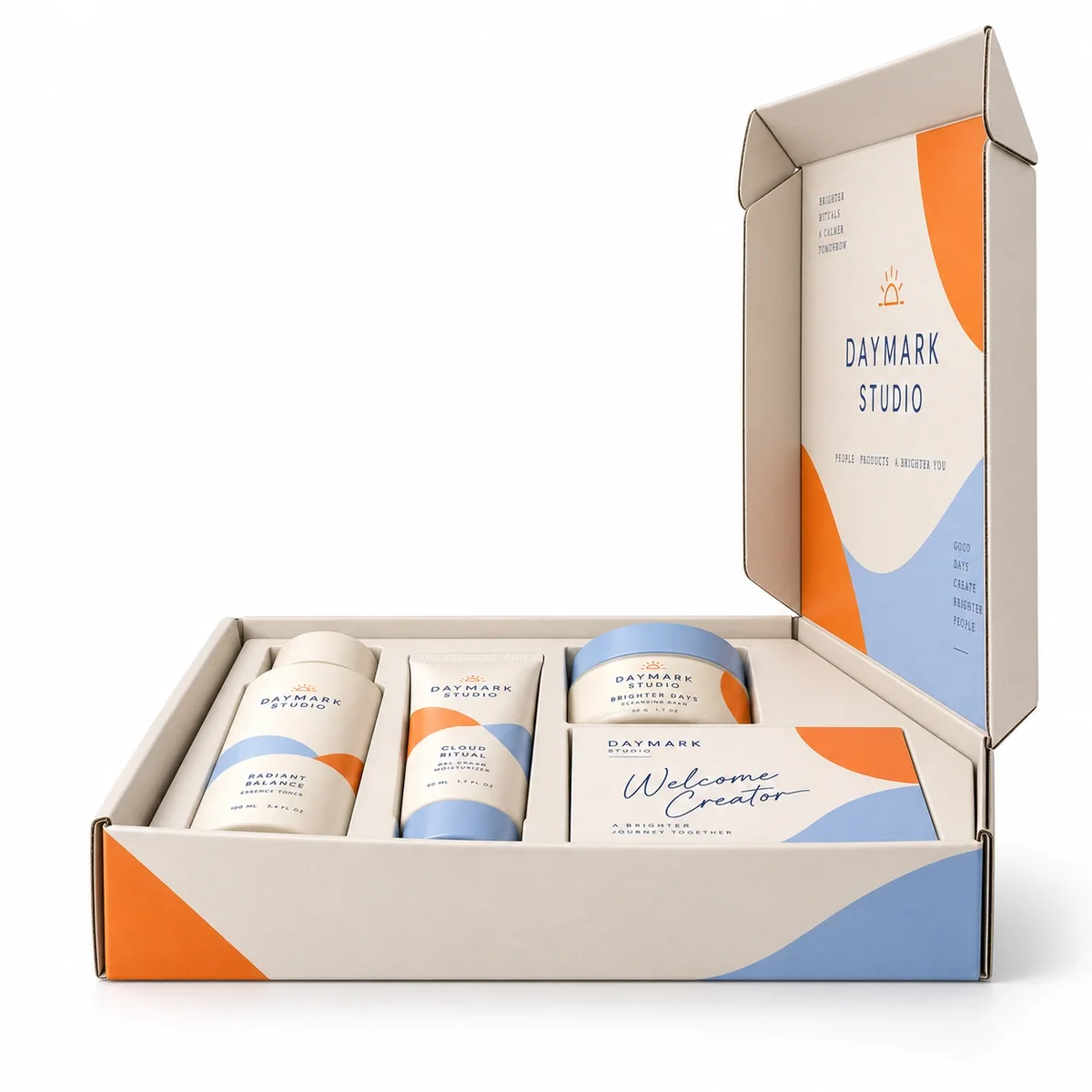 Side profile of open DAYMARK STUDIO influencer kit packaging showing the upright printed lid, ivory box walls and arranged samples.