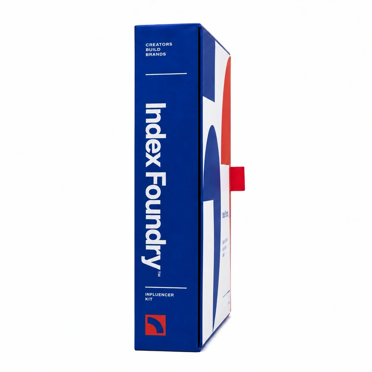 Side profile of cobalt-blue custom influencer kit packaging with white editorial typography, red graphic accents and a pull tab.