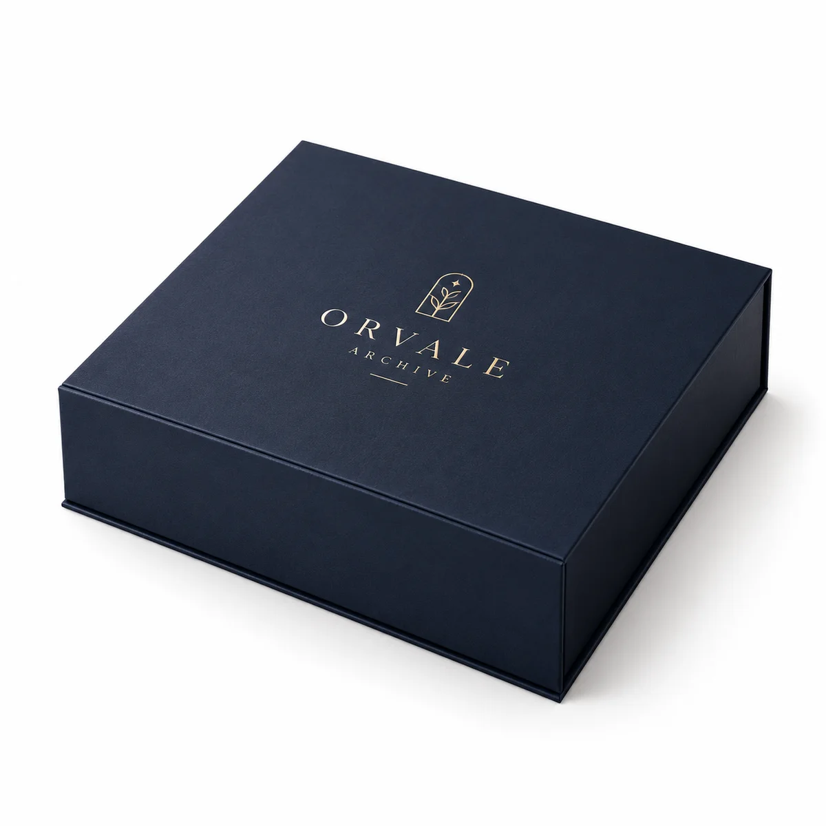 Closed navy magnetic closure rigid box for Orvale Archive, photographed at an elevated angle with a centered champagne-gold foil mark.