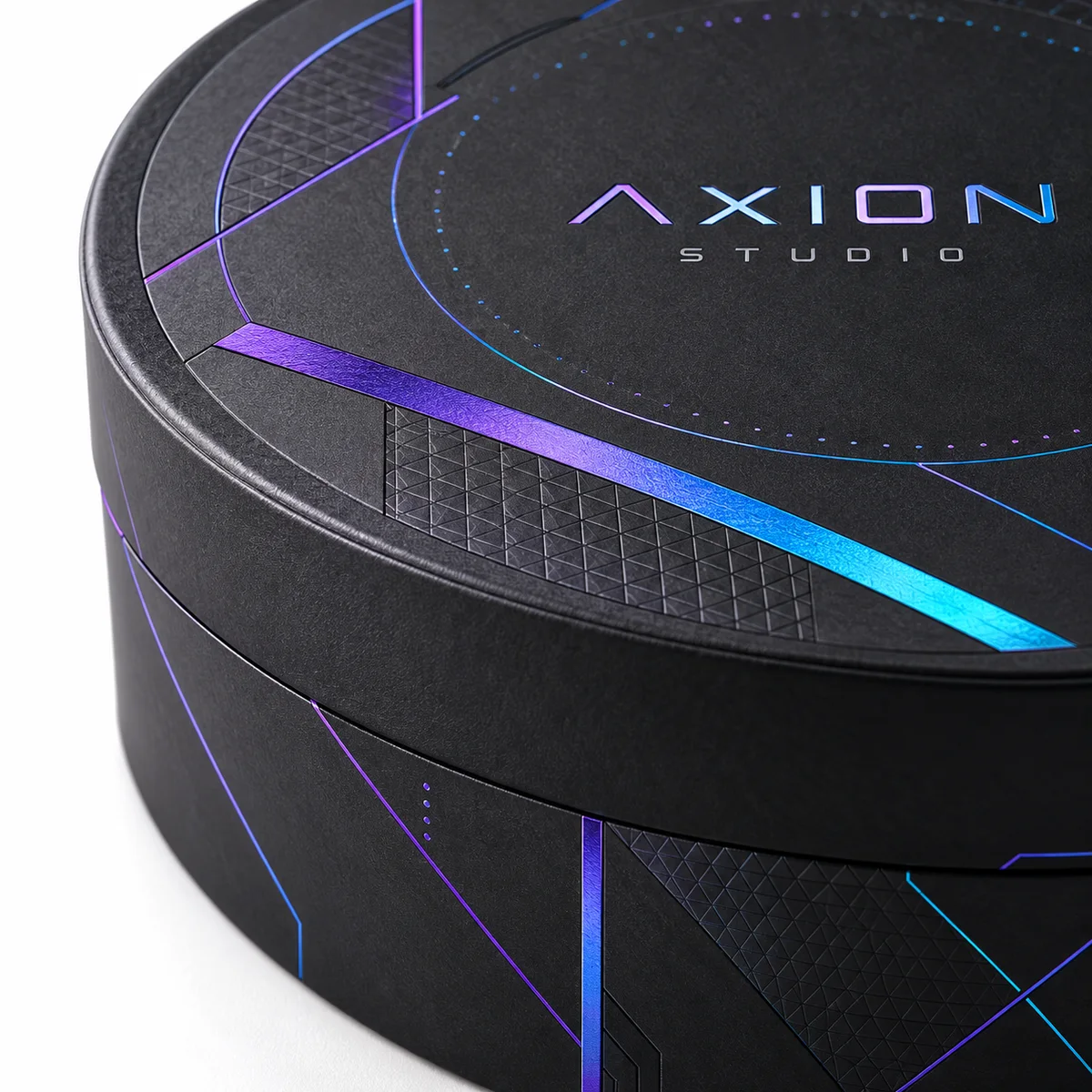 Close-up of a black round gift box lid with AXION STUDIO branding and electric blue and violet geometric details.
