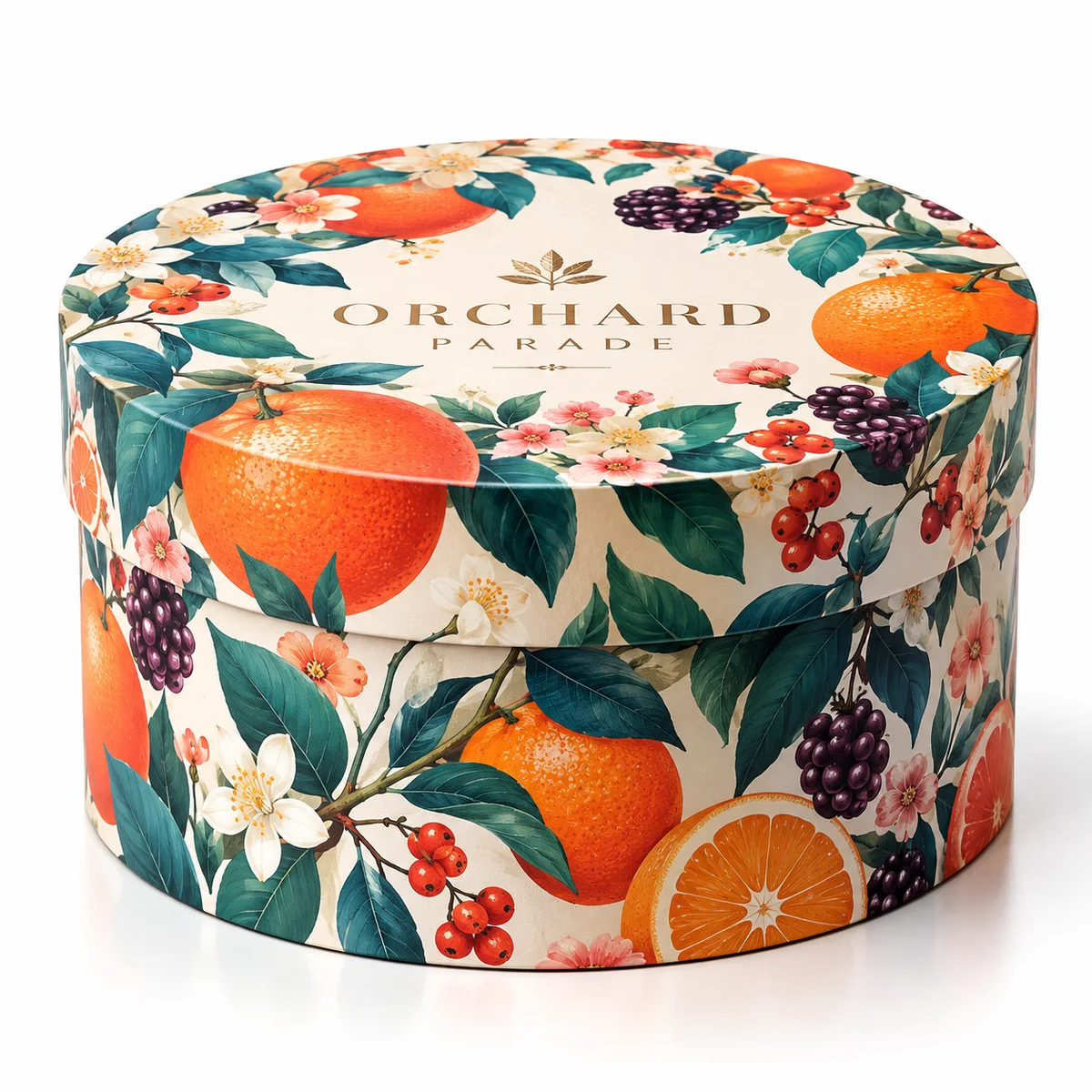 Round gift box covered with colorful citrus, berries, flowers and teal leaves, featuring ORCHARD PARADE branding.