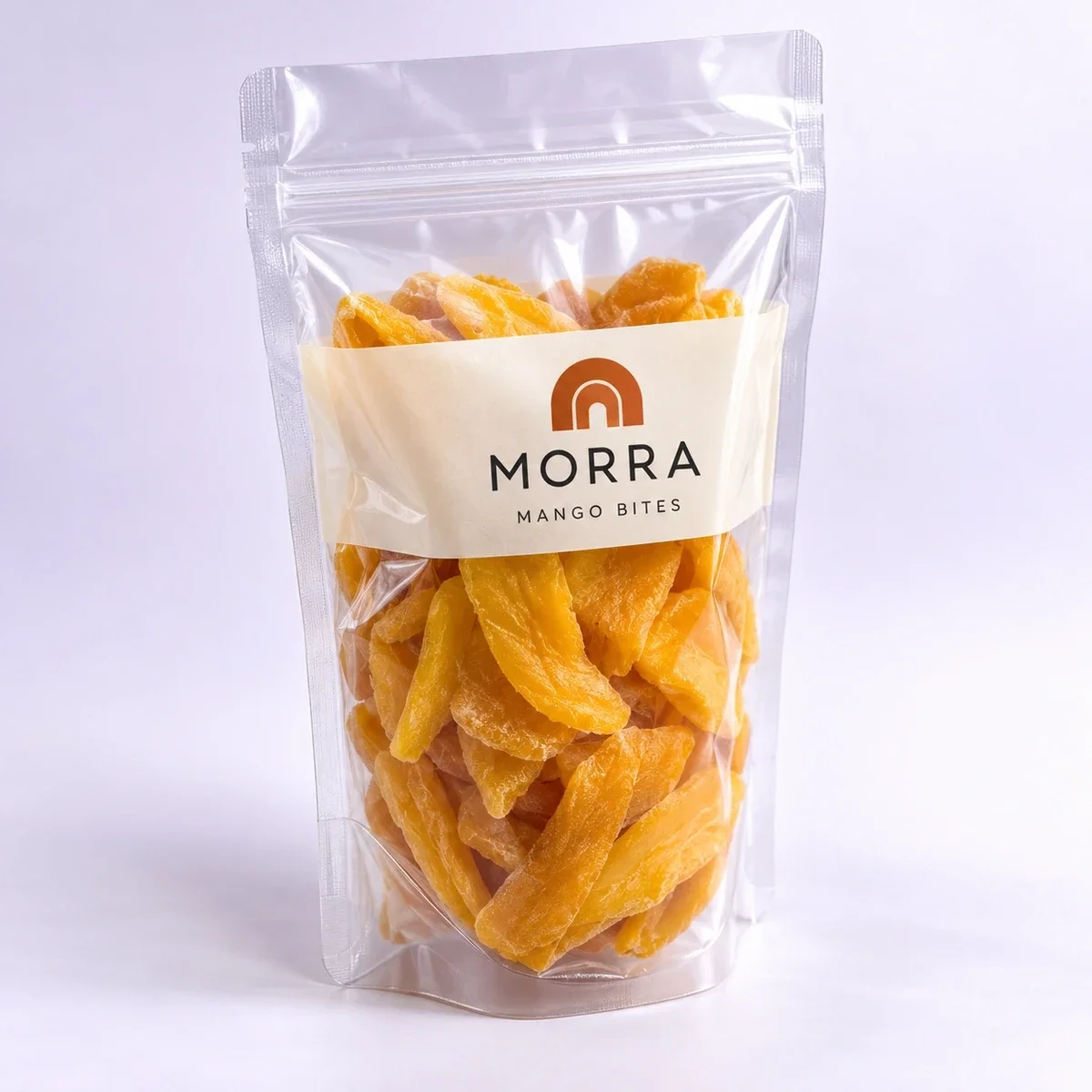 Three-quarter hero view of a clear MORRA Mango Bites stand-up pouch with dried mango visible through the film.