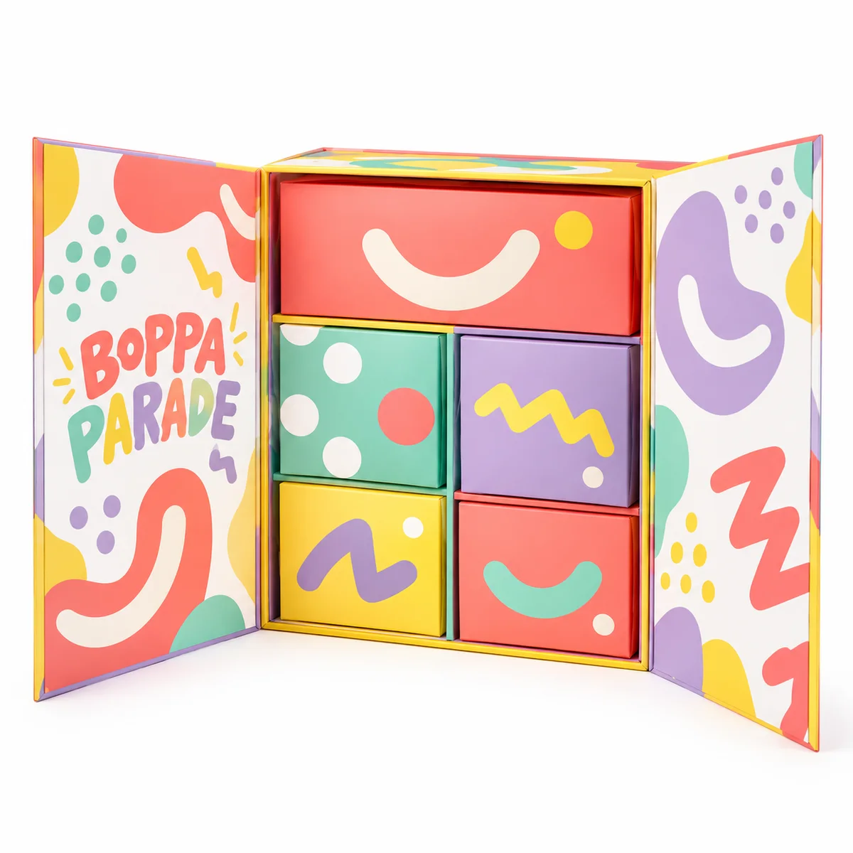 Open double-door Boppa Parade magnetic gift box with playful pastel shapes and colorful compartments arranged inside.