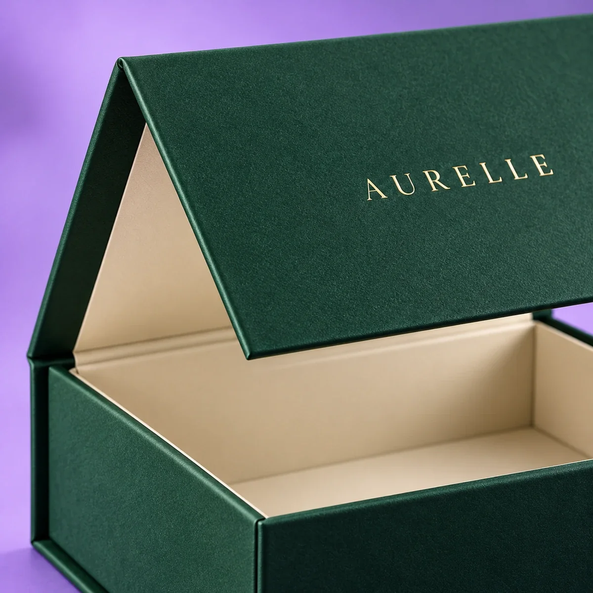 Close-up of an emerald green magnetic gift box highlighting its textured lid, gold foil lettering, and folded edges