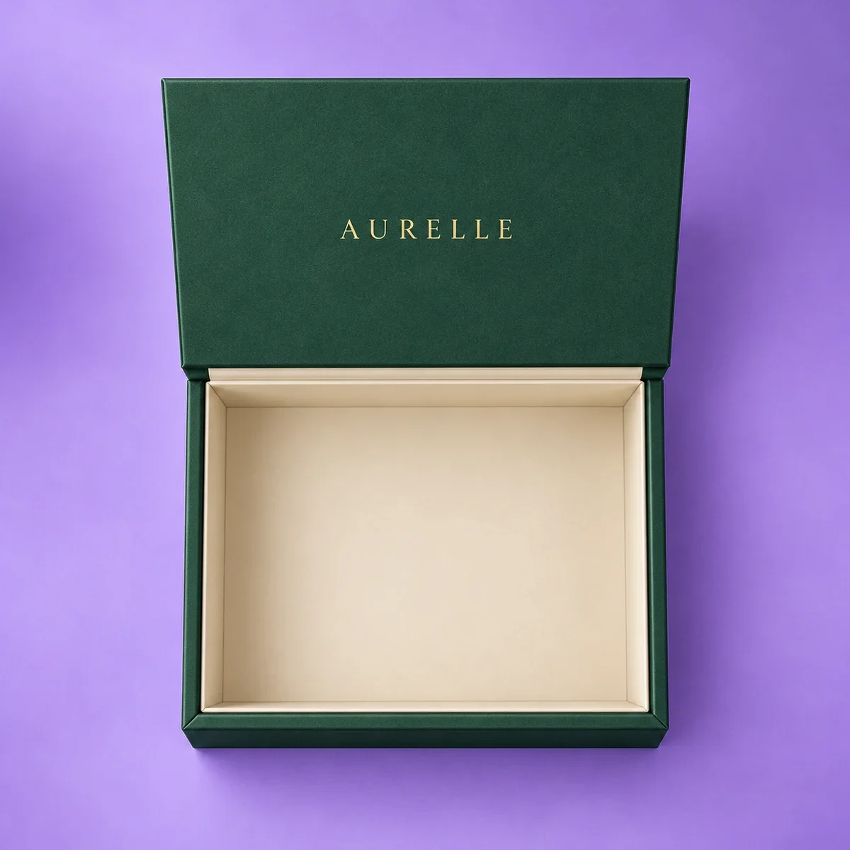 Top-down view of an open emerald green magnetic gift box showing its spacious cream interior and gold lettering