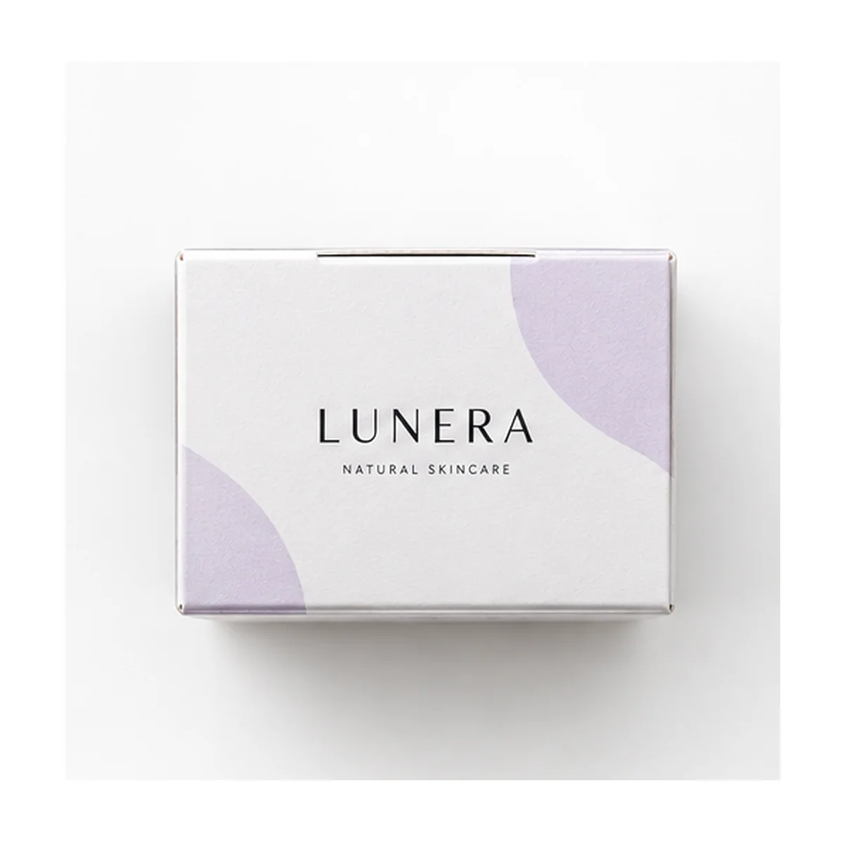 Overhead view of a white tuck top packaging box showing LUNERA branding, pale lavender graphic accents, and its folded top closure.